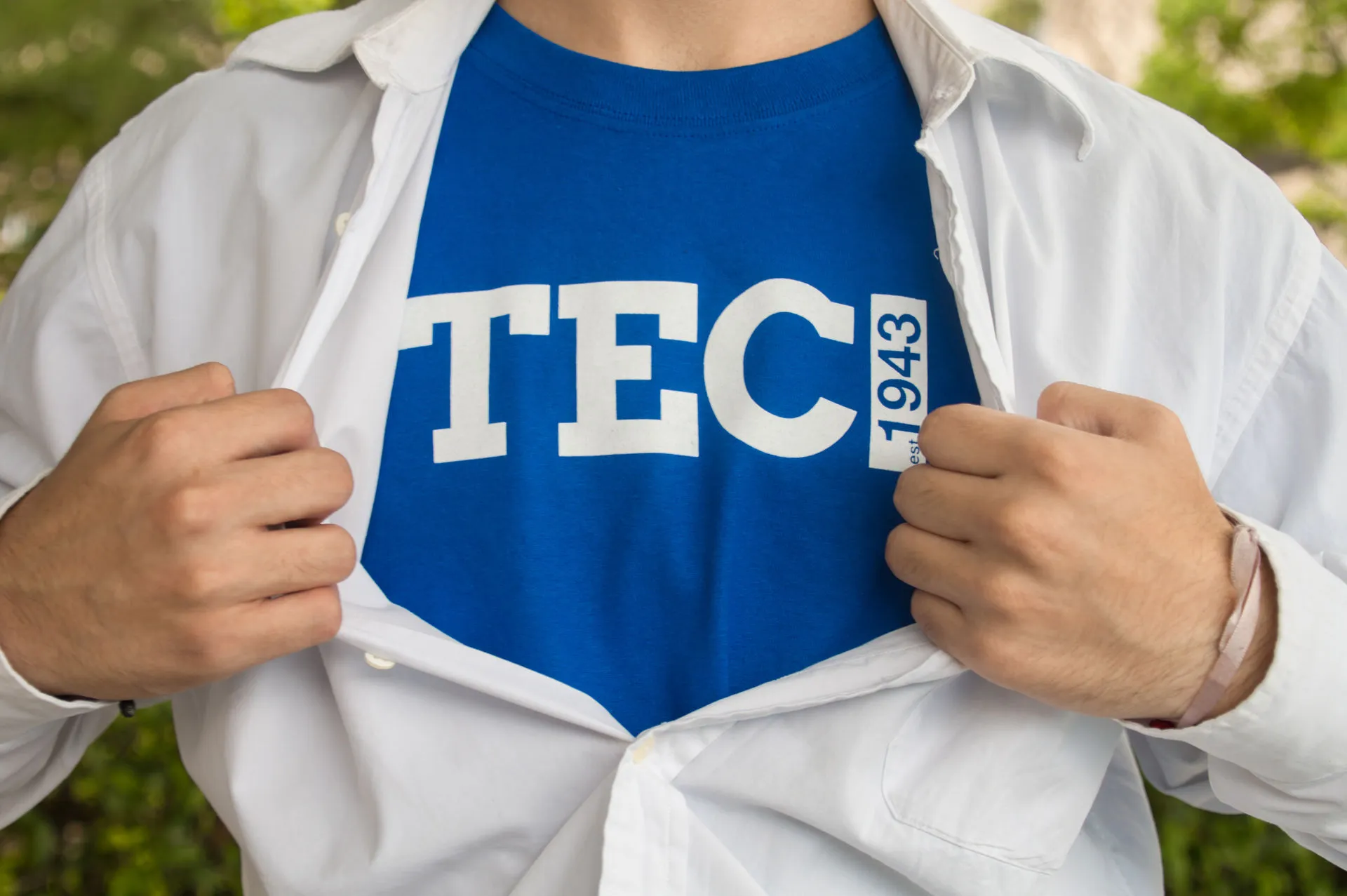 Jovén con playera azul debajo de camisa blanca