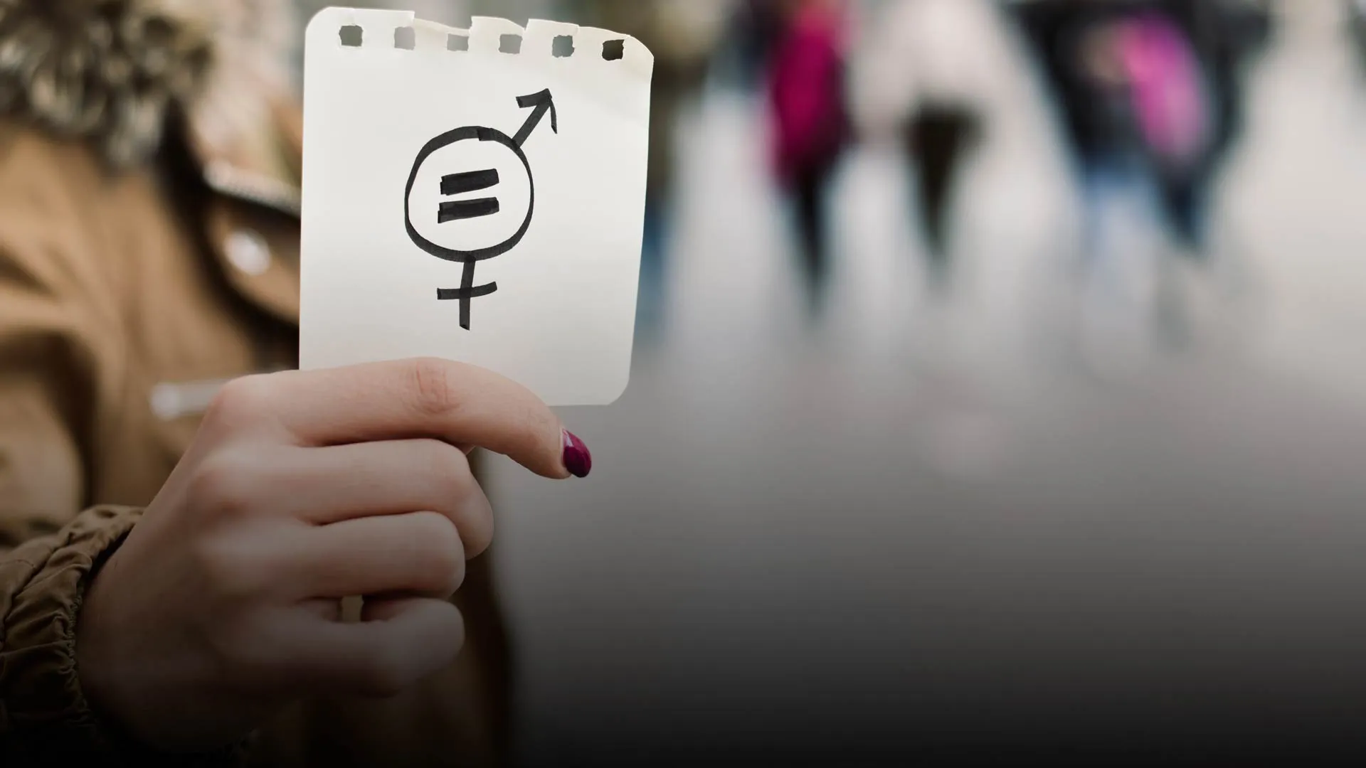 Mujer sosteniendo una hoja con signo de igualdad de género