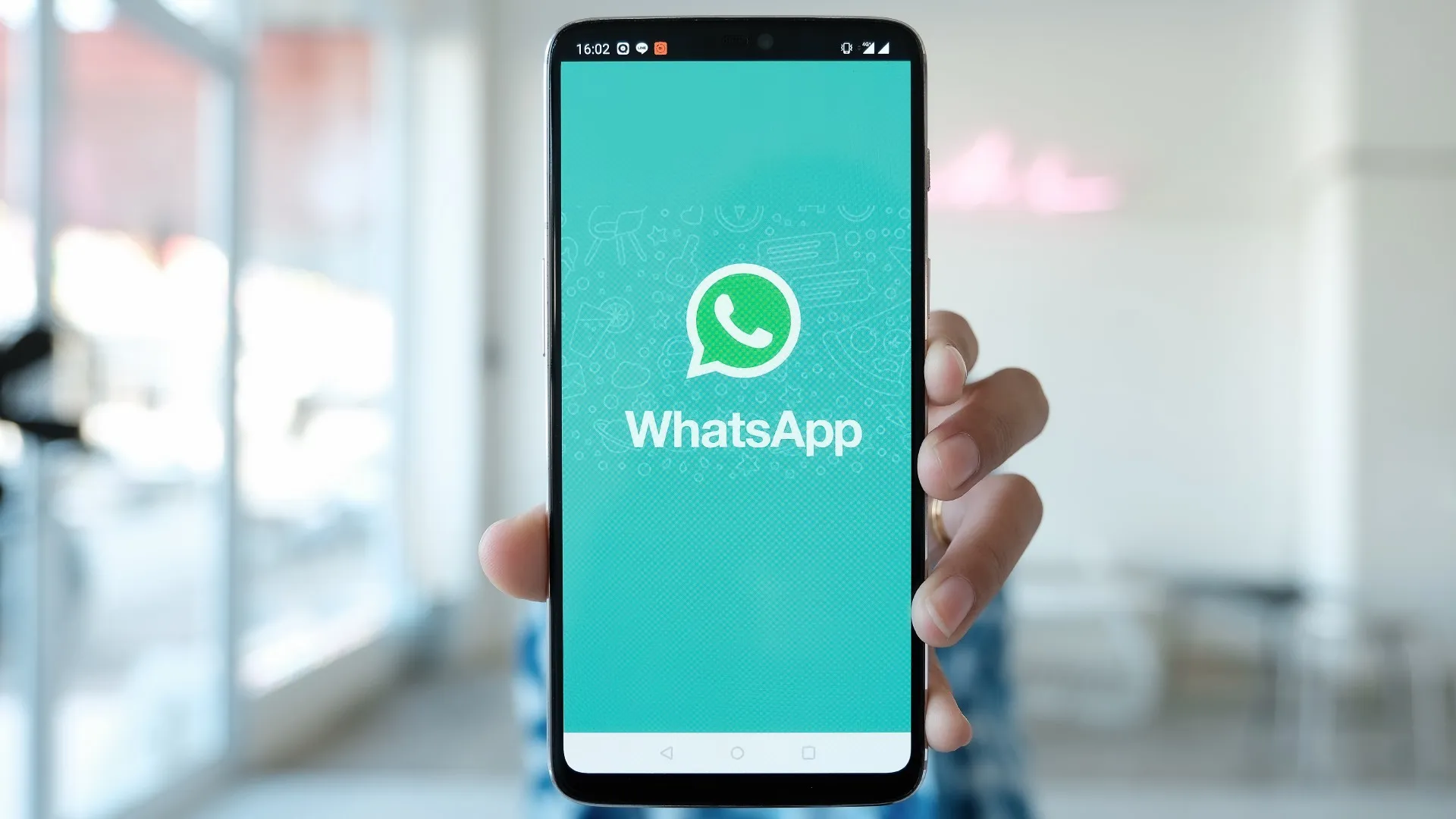 Mano sosteniendo celular con WhatsApp