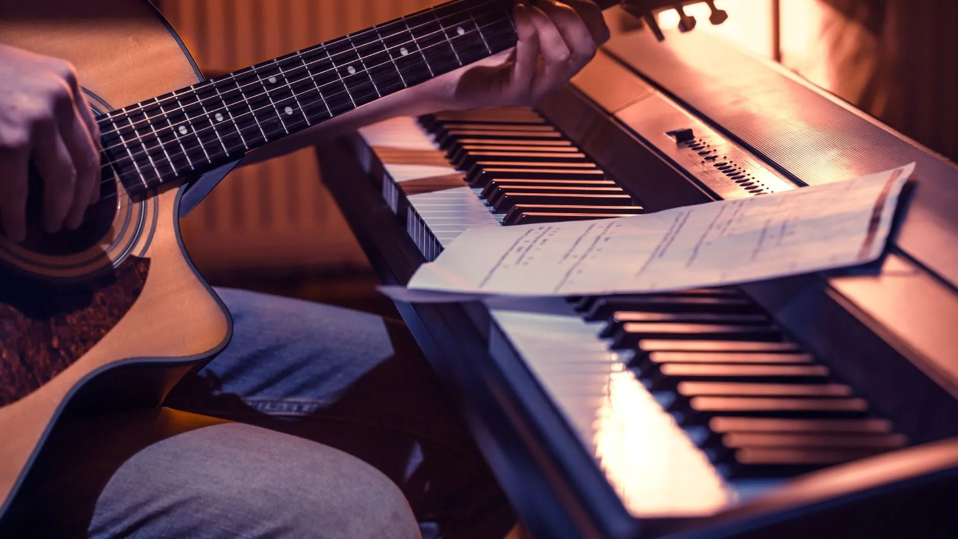 hombre-tocando-guitarra-junto-a-un-teclado