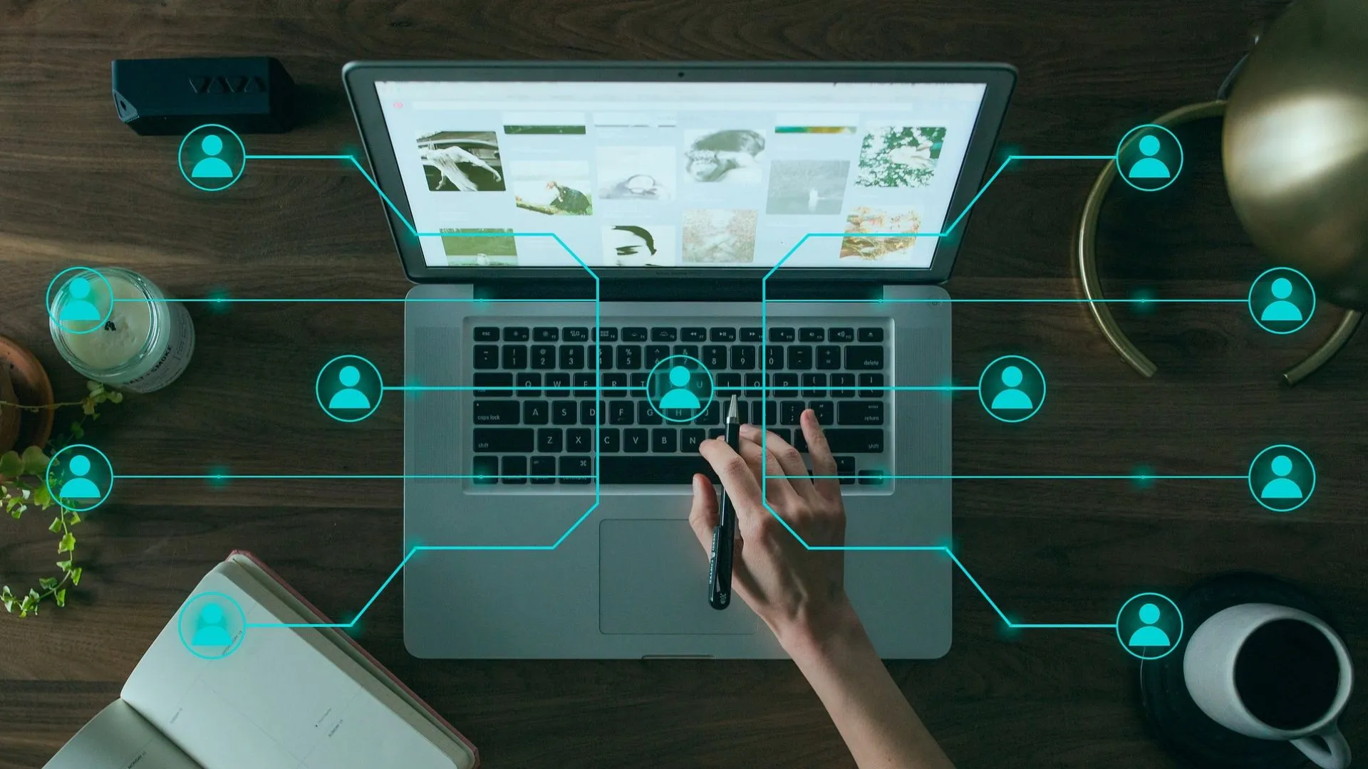 Laptop sobre escritorio, encima hay una imagen de red de contactos y una mano en el teclado.