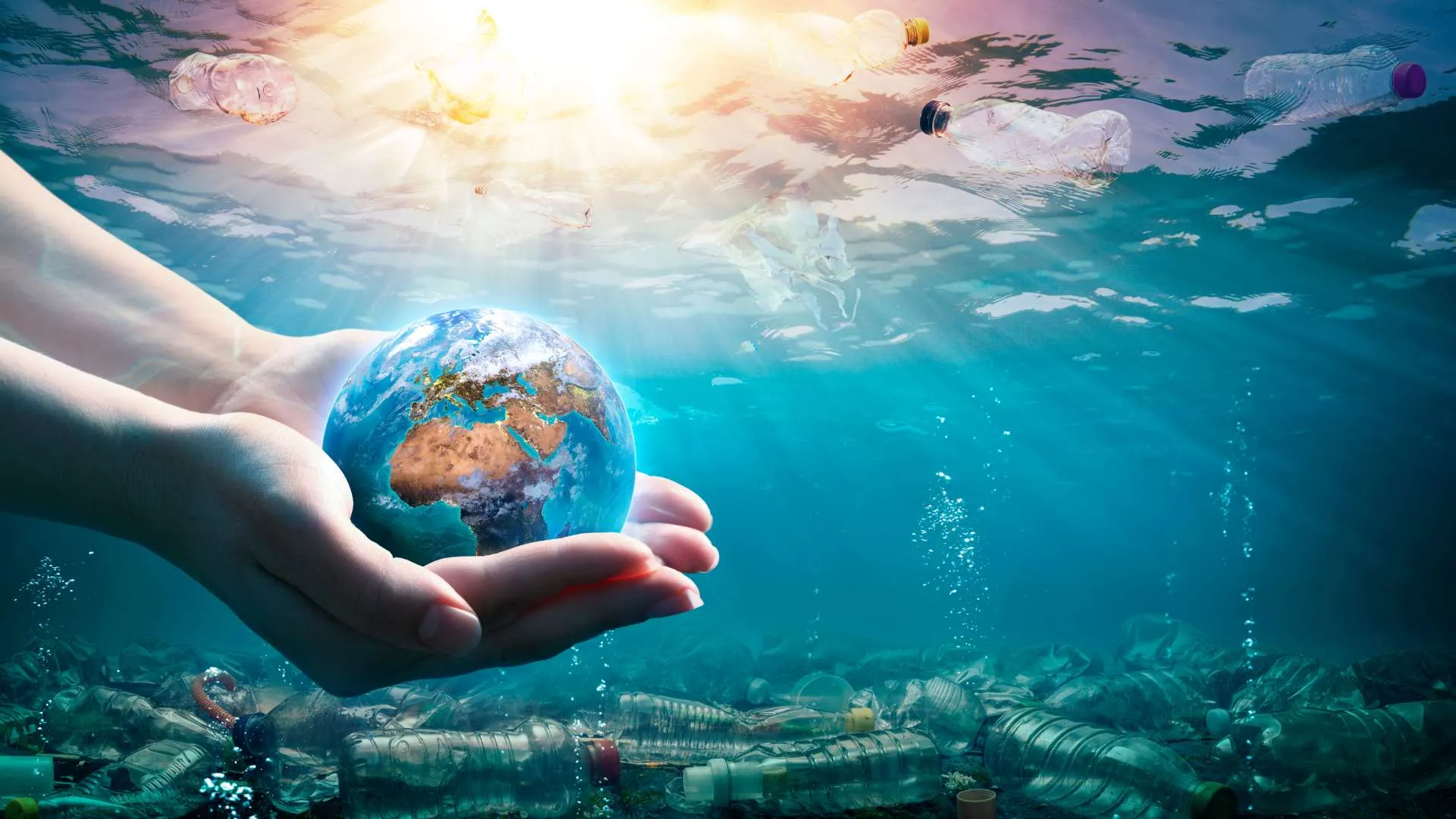 Image of the ocean contaminated with the world held in between two hands