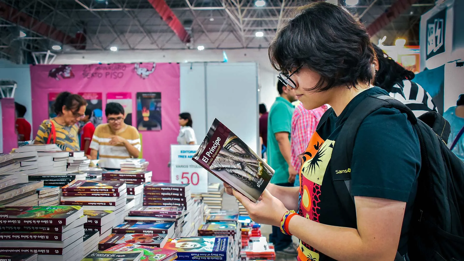 Chica joven en la Feria del Libro Monterrey, con el libro El 