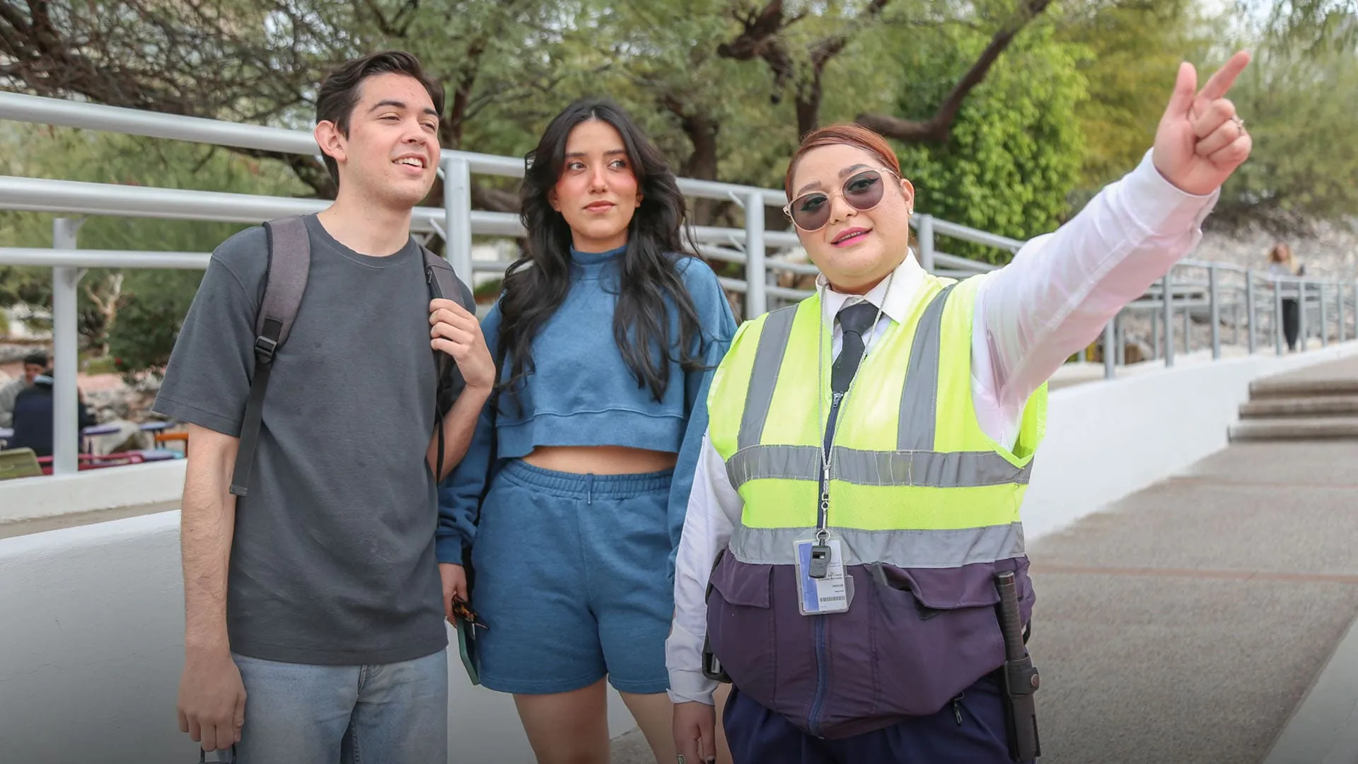 Guardia de seguridad ayudando a dos estudiantes