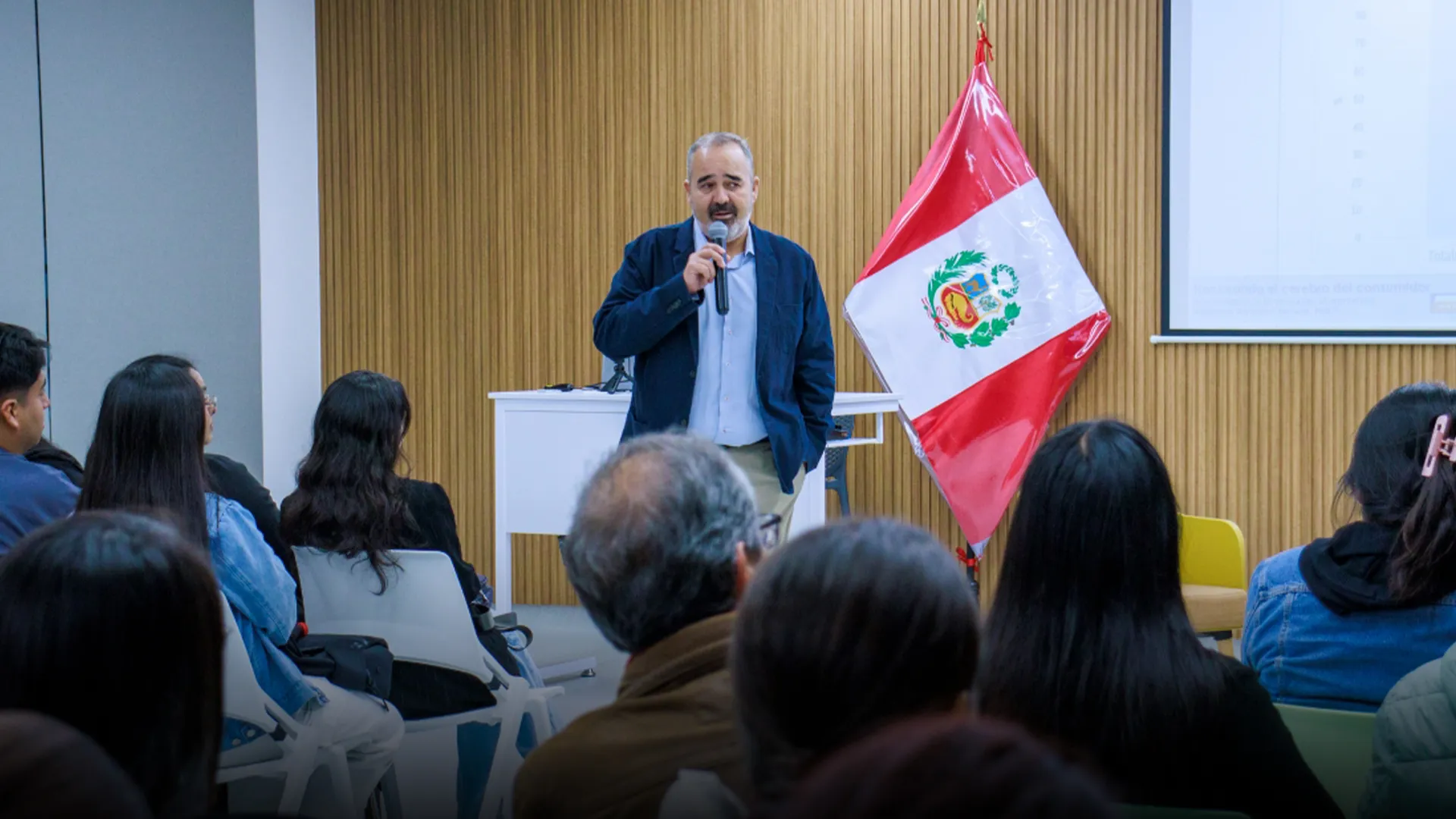 Profesor hablando frente a público. 