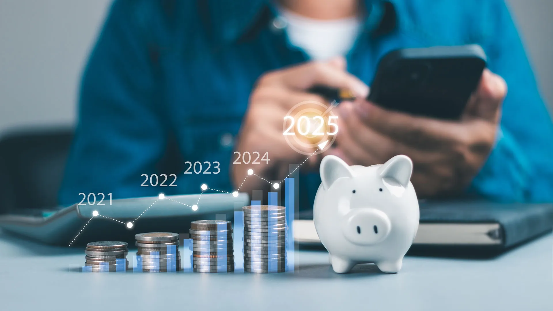 Foto conceptual de una persona calculando sus finanzas, y al frente una alcancía con monedas a lado