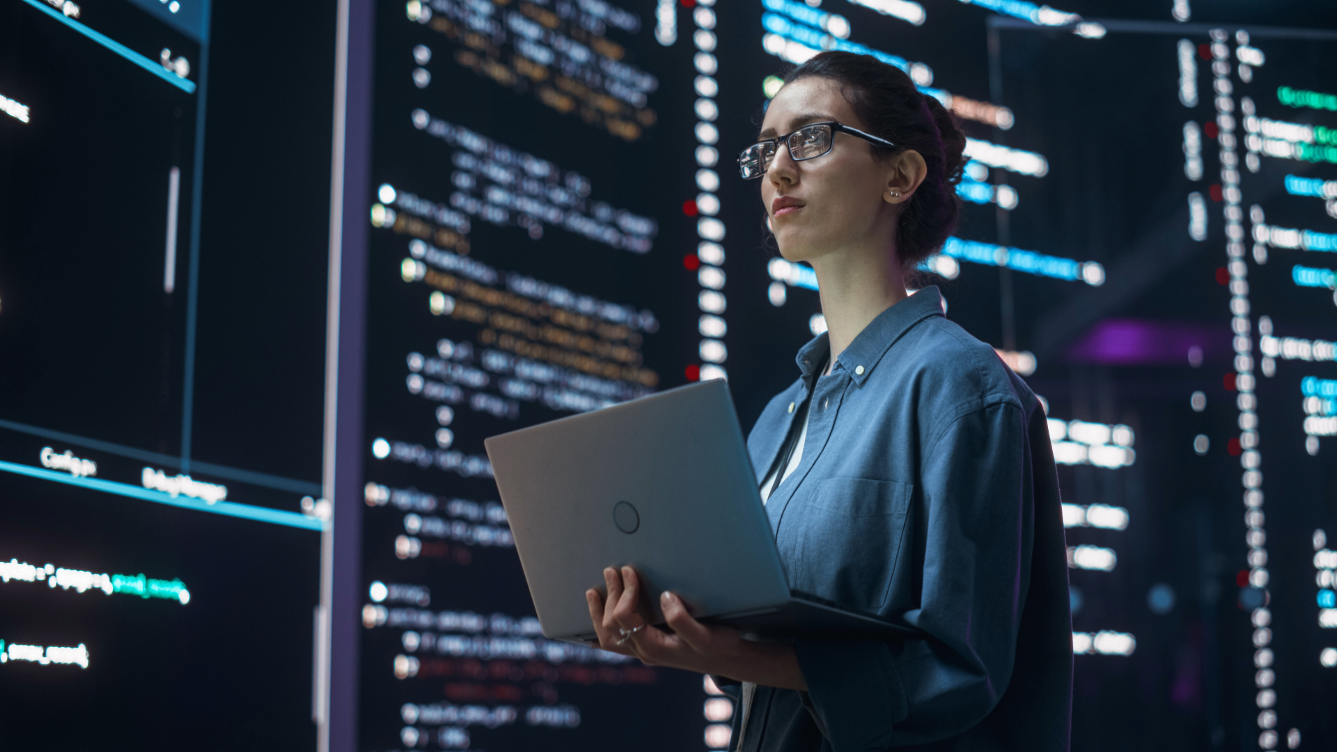 mujer con laptop viendo pantallas