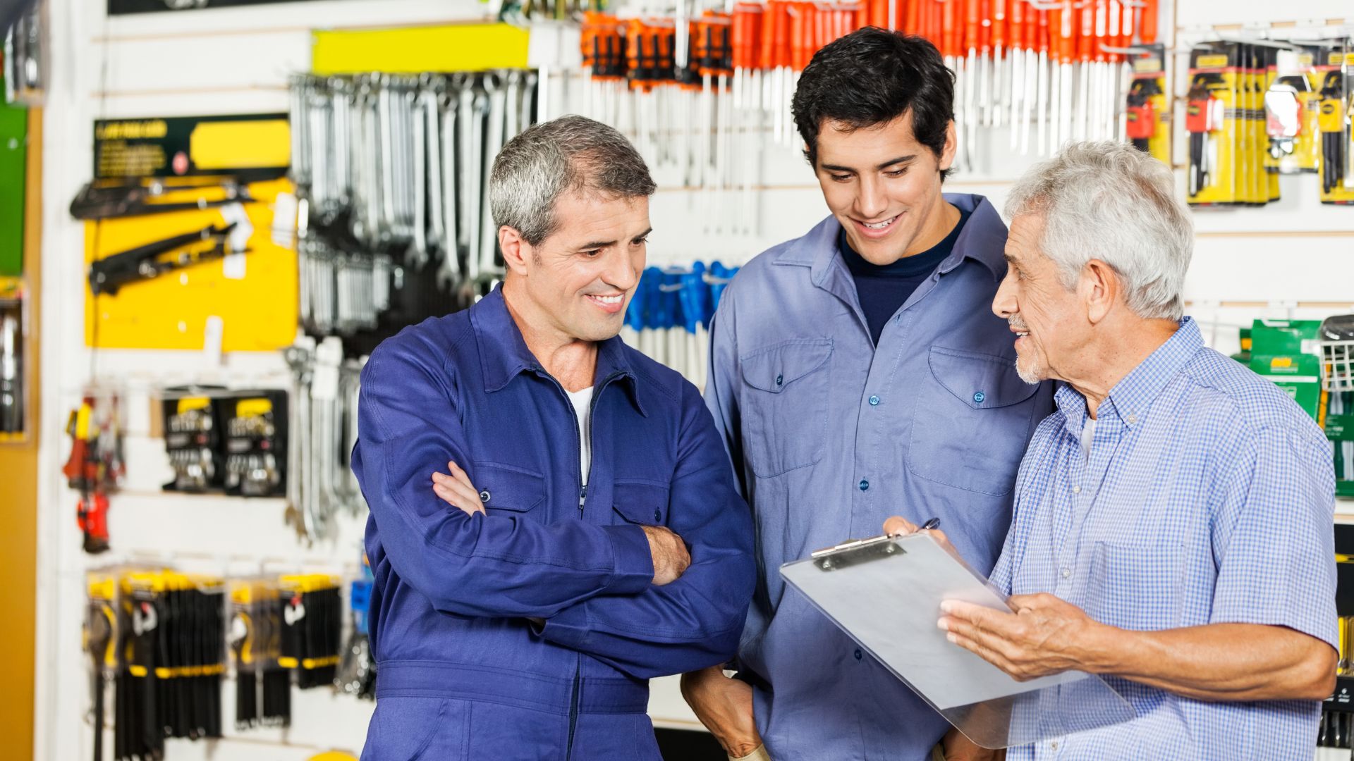Tres generaciones de hombres platicando en una ferretería, concepto de una empresa familiar