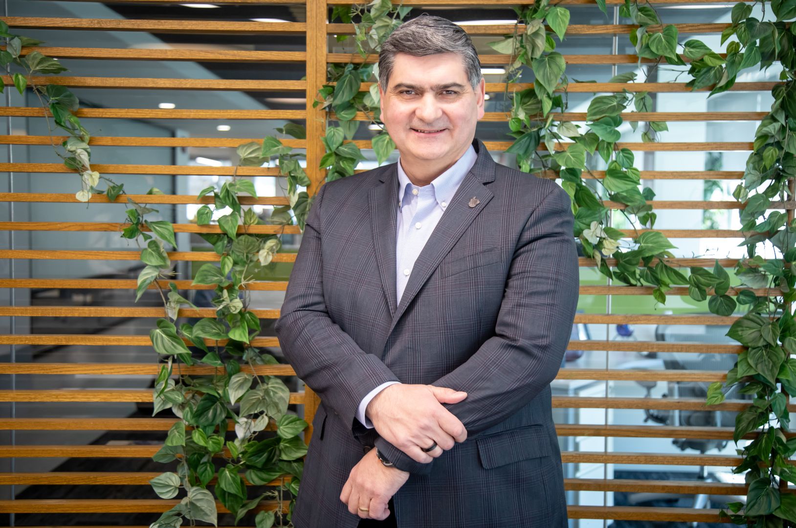 David Garza, presidente ejecutivo del Grupo Educativo Tecnol&oacute;gico de Monterrey, posa en un espacio interior con plantas y celos&iacute;a de madera.