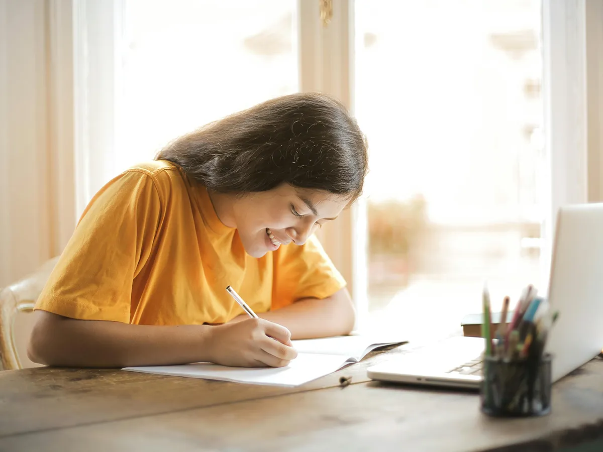 Estudiante tomando notas en un cuaderno