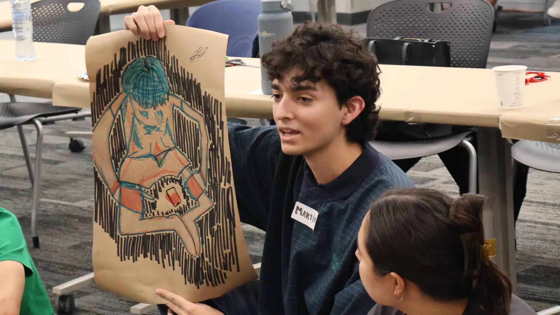 Becario de la primera generación del curso mostrando un dibujo