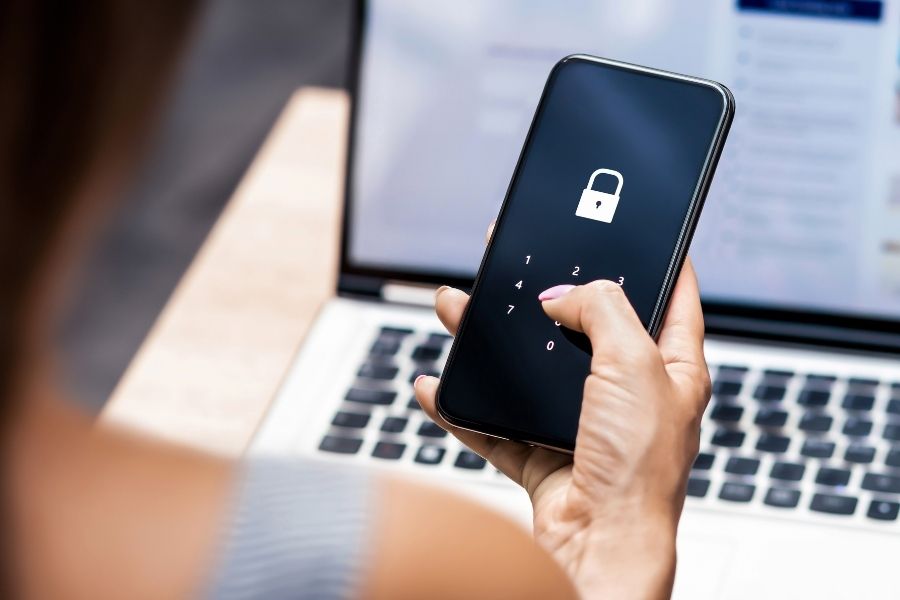 Celular en manos de persona con pantalla mostrando seguridad para que no haya filtraci&oacute;n de datos