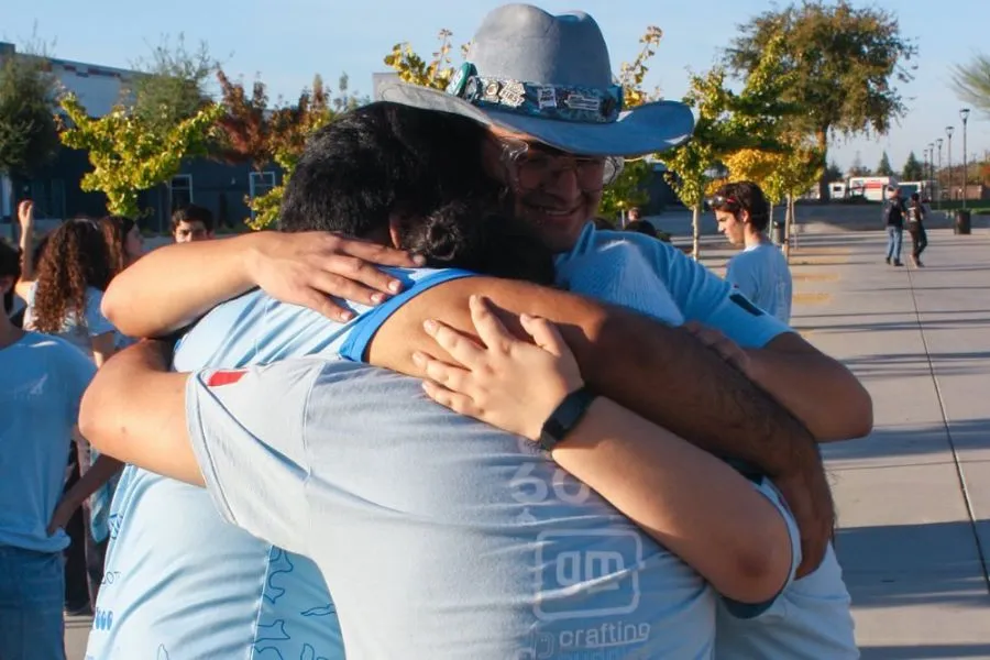 Pepe Santill&aacute;n abraza a otros coaches del equipo Cyberius 6017 durante una competencia de FIRST Robotics.