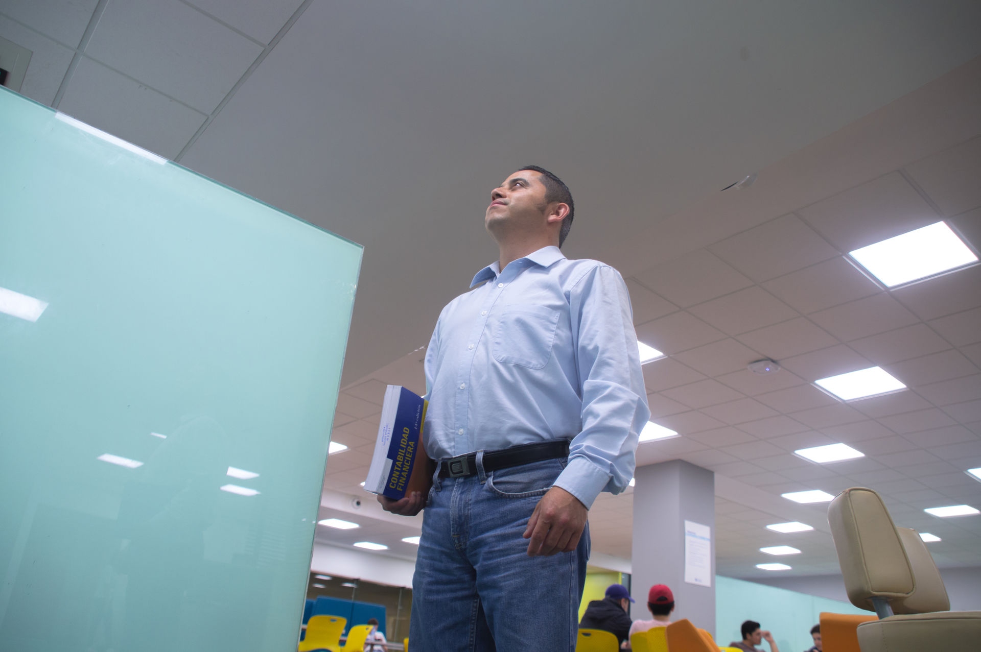 Hombre mirando hacia el horizonte con un libro en la mano