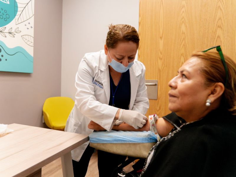 Enfermera obteniendo muestra de sangre de paciente de la Clínica ELA.