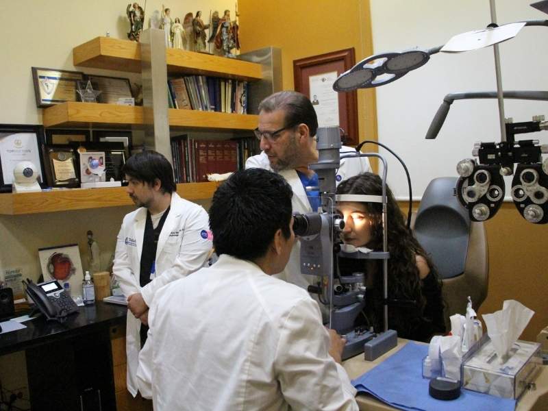 Médico especialista guía a un estudiante durante una consulta oftalmológica en TecSalud.