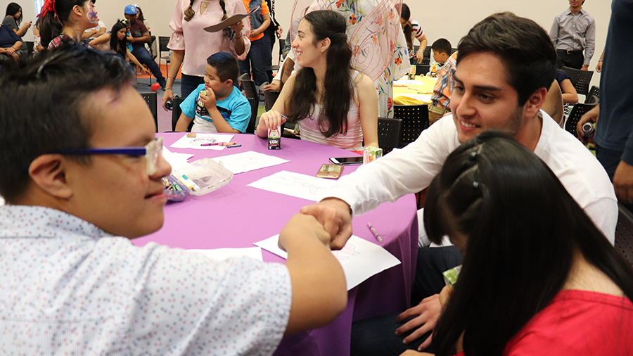 Alumno chocando el puño con un niño