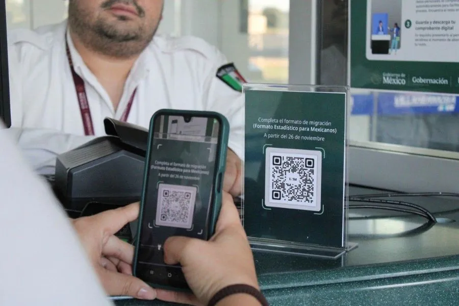 Persona escanea un c&oacute;digo QR en el aeropuerto para llenar el Formato Migratorio digital antes de abordar su vuelo.