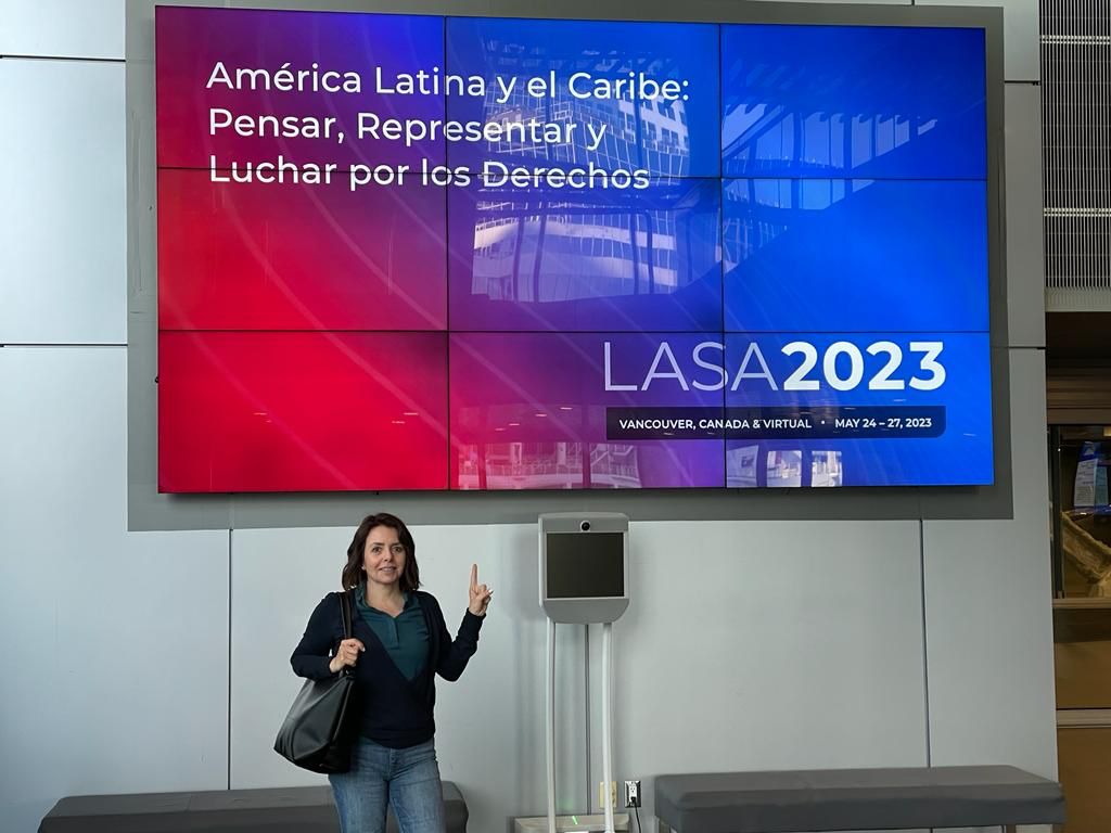 Lorena Nieto posando enfrente de cartel sobre LASA 2023.