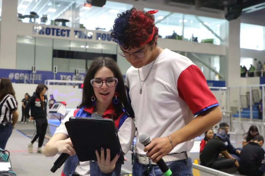 Pepe Santill&aacute;n y Samantha Mu&ntilde;oz posan juntos durante una competencia de FIRST Robotics, donde participan como narradores.
