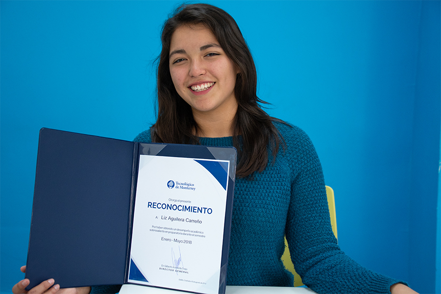 Liz con su reconocimiento a la excelencia academica