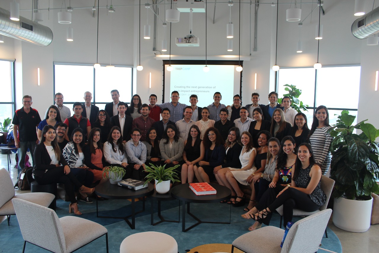 Jóvenes emprendedores en una sala de juntas posando para una foto