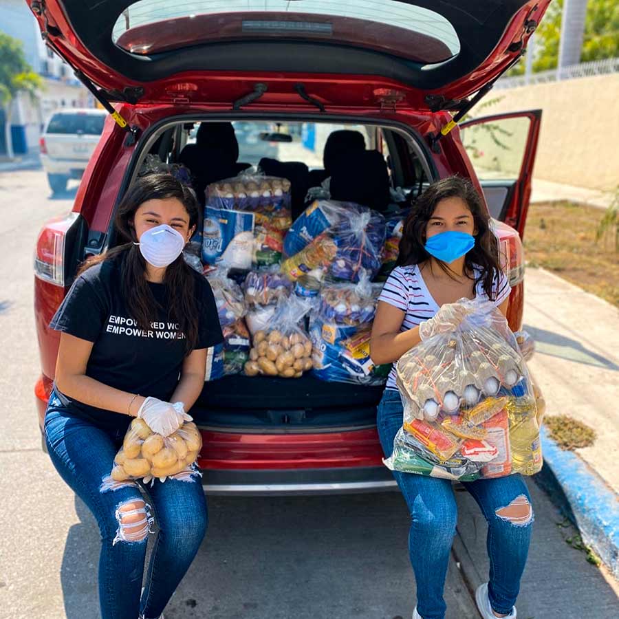 Aida Paredes y Daisy Gallardo en una camioneta llena de despensas