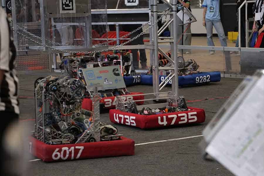 Robots de la alianza roja y azul en la cancha durante el juego de final.