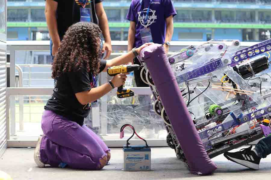 Alumna de PrepaTec Monterrey verifica funcionamiento de robot.