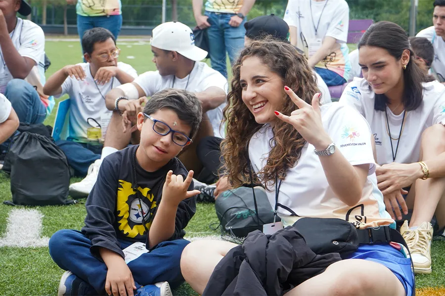Alumna sonriendo con ni&ntilde;o en campamento Vive Extremo.