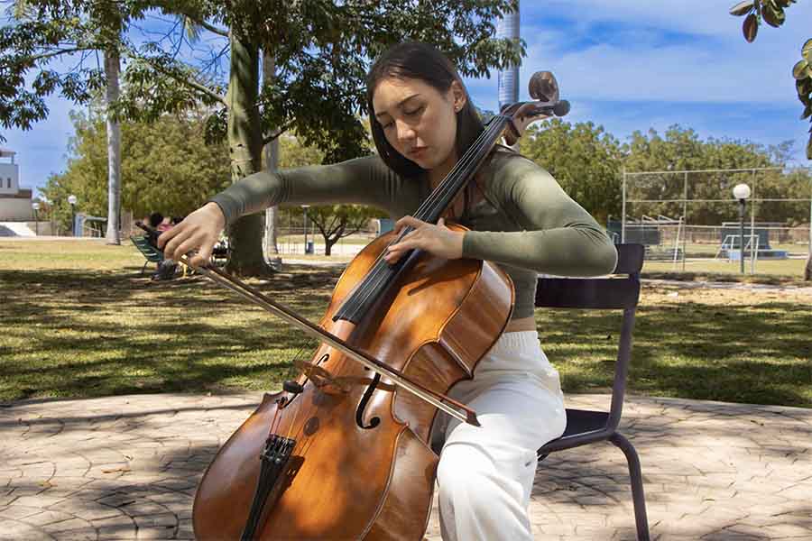 alumna tocando el cello en pasillo life