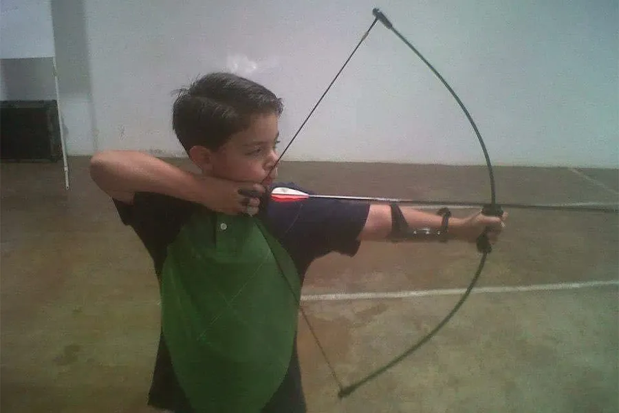 Arquero Hugo Cueto sosteniendo arco cuando era niño.
