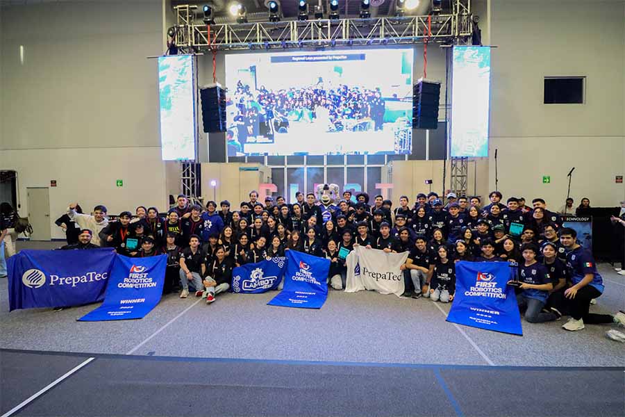 Miembros de equipos ganadores del torneo FIRST posan con sus banners.