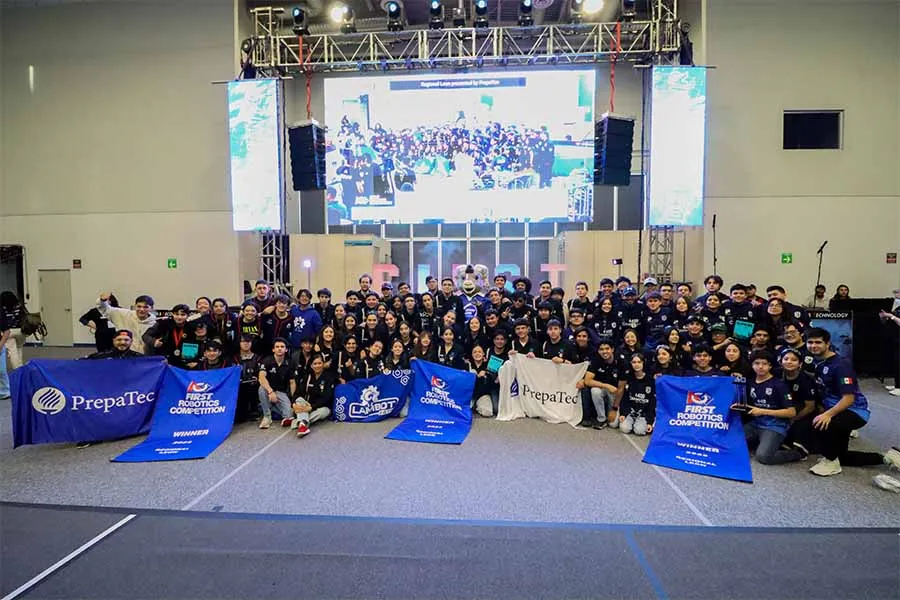 Miembros de equipos ganadores del torneo FIRST posan con sus banners.