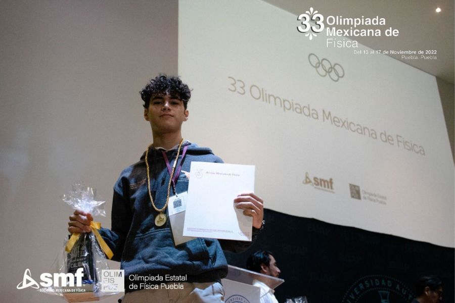 Victor recibiendo medalla de oro en la olimpiada de fisica.