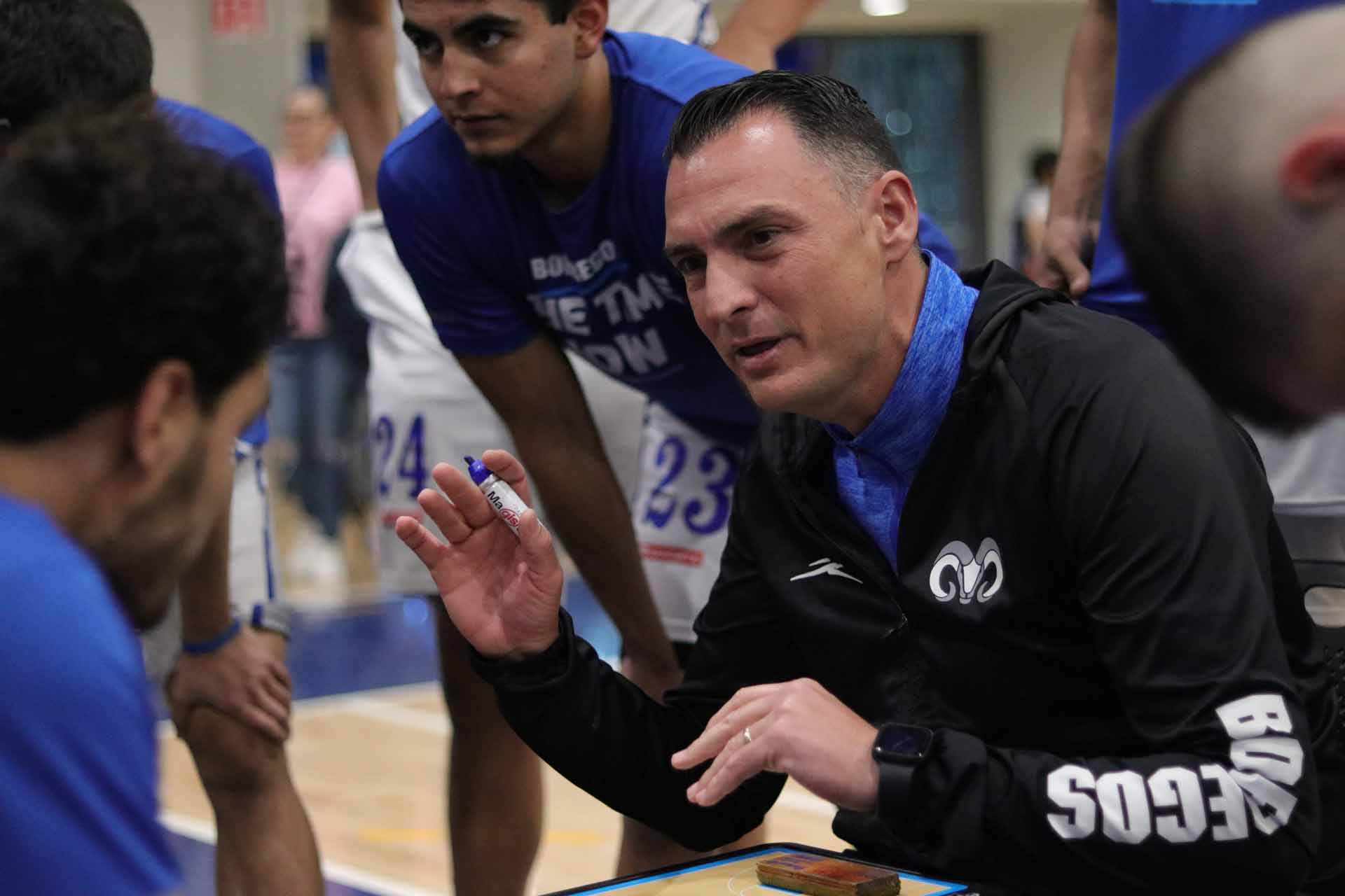 Sergio Molina, entrenador del equipo platicando con los jugadores