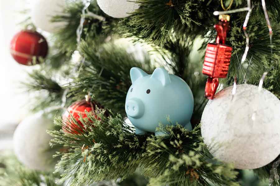 Alcancía en forma de cochinito, en árbol de navidad, concepto de ahorro en época decembrina