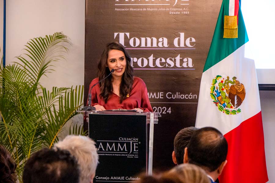 Dorina tomando protesta frente a público como presidenta de ammje