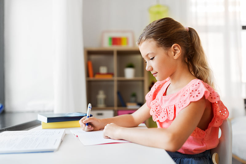 Niña estudiando en casa