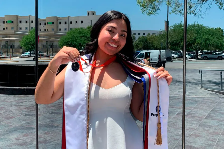 Egresada de PrepaTec Laguna posa para fotografía con sus estolas, medalla de liderazgo y cordón de mención honorífica de excelencia