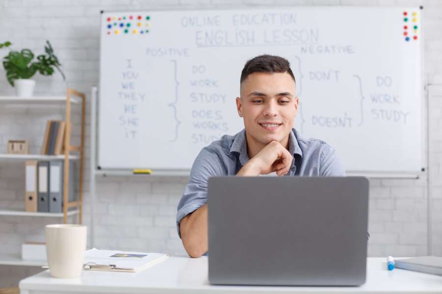 Hombre joven tomando clases de inglés a través de la computadora