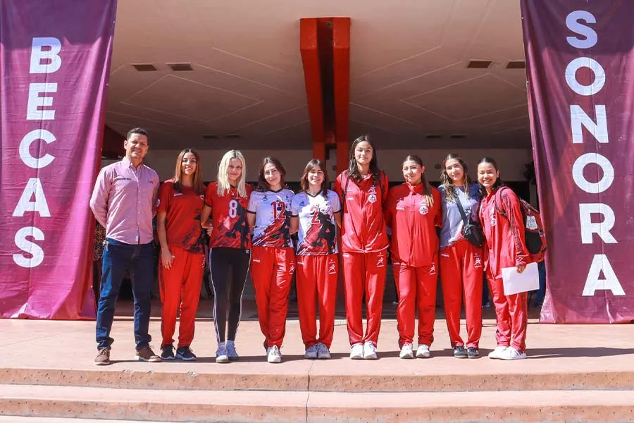 Equipo de voleibol femenil posando juntas.