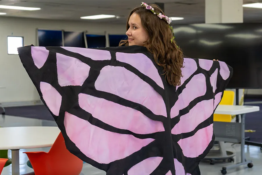 Estudiante posando con su capa.