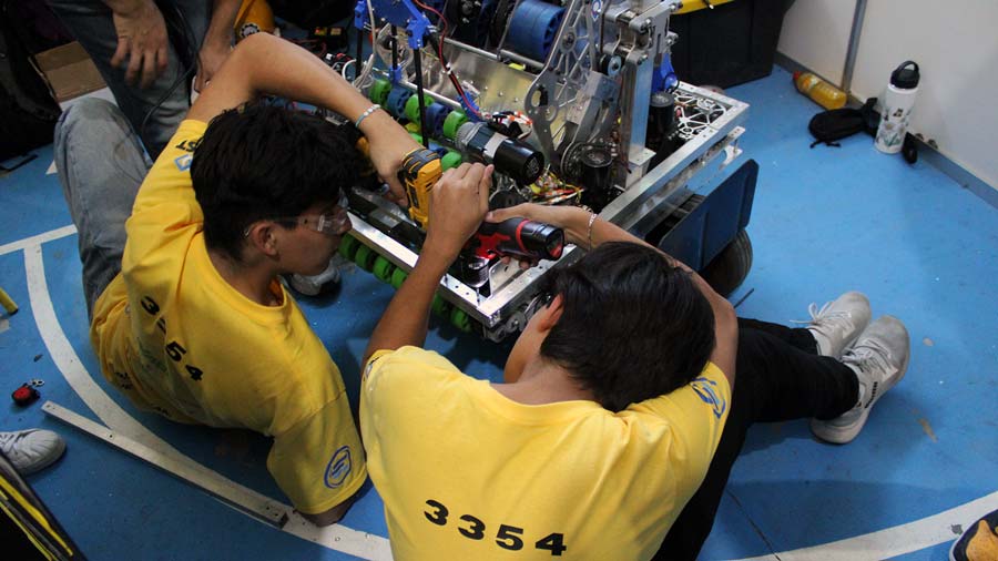 Estudiantes del equipo de robótica de campus Querétaro arreglando los últimos detalles de su robot
