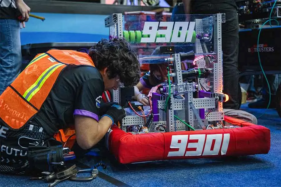 Estudiantes del Tec de Monterrey realizan ajustes técnicos a su robot durante la FIRST Robotics Competition.
