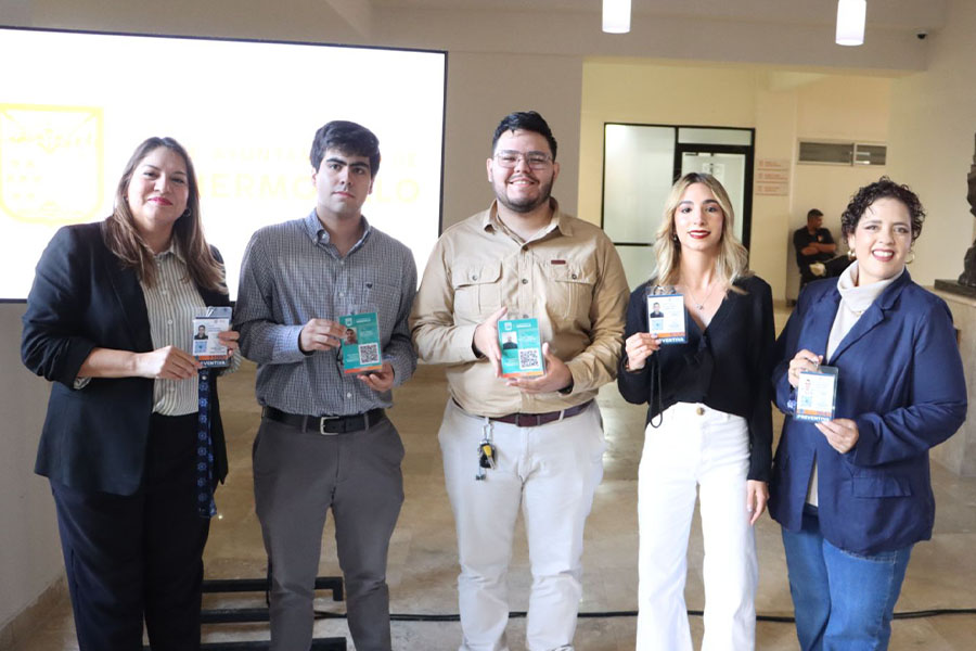 5 personas posando sosteniendo gafetes con códigos QR.