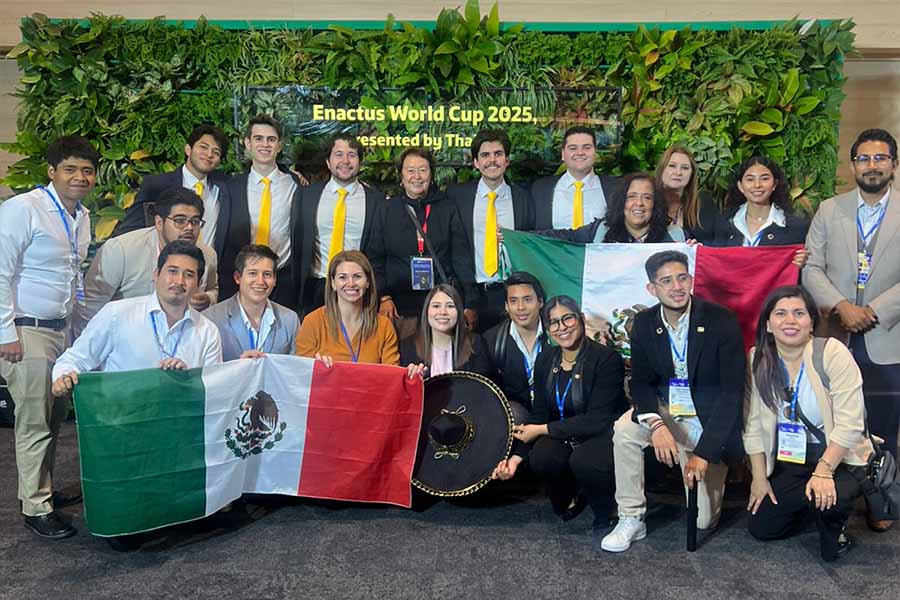 Grupo de varias personas posando juntos con banderas mexicanas. 