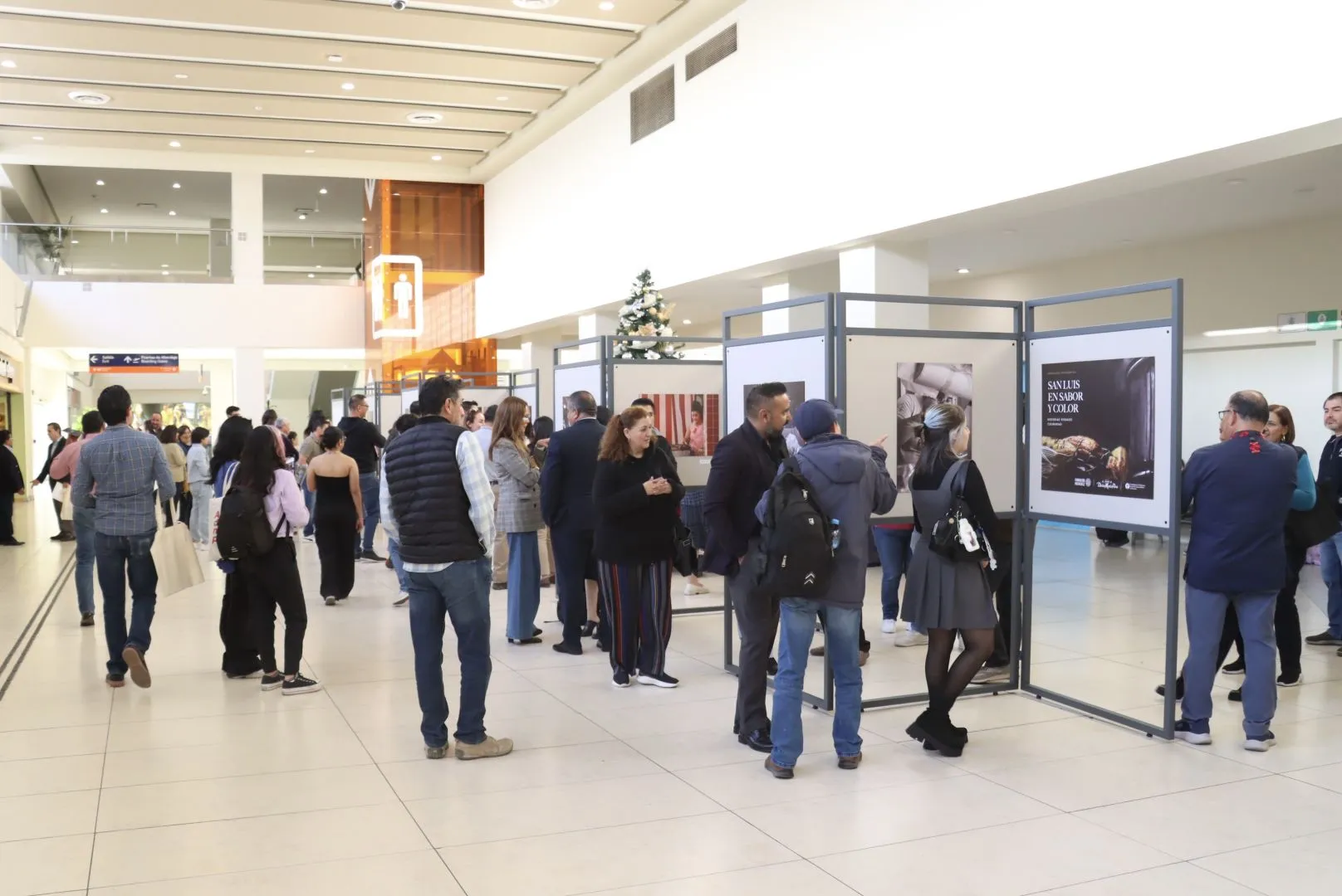 estudiantes y visitantes en la exposición