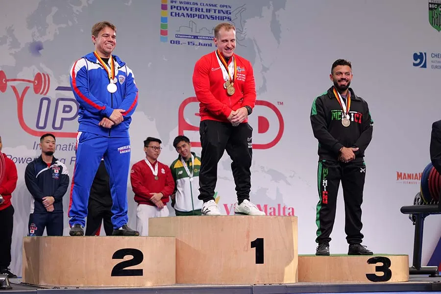 Tres hombres en un podio portando sus medallas.