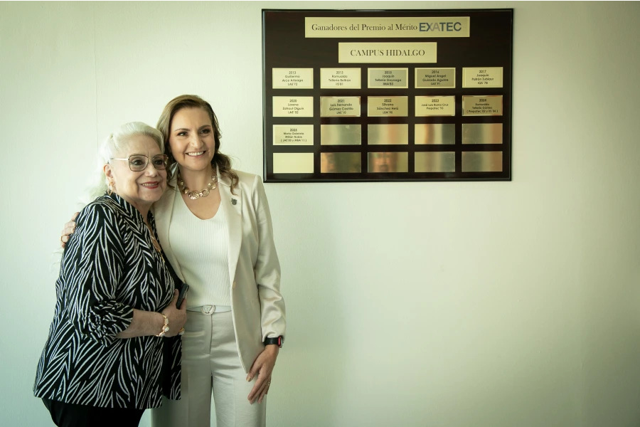 Gabriela Millán, ganadora del Premio al Mérito EXATEC 2025, posa con un familiar junto a su placa de reconocimiento en el Tec de Monterrey campus Hidalgo.